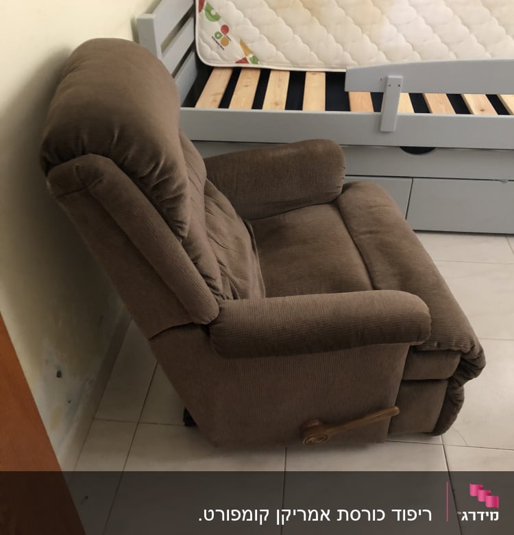 כורסה מרופדת חומה ליד מיטה עם מזרן